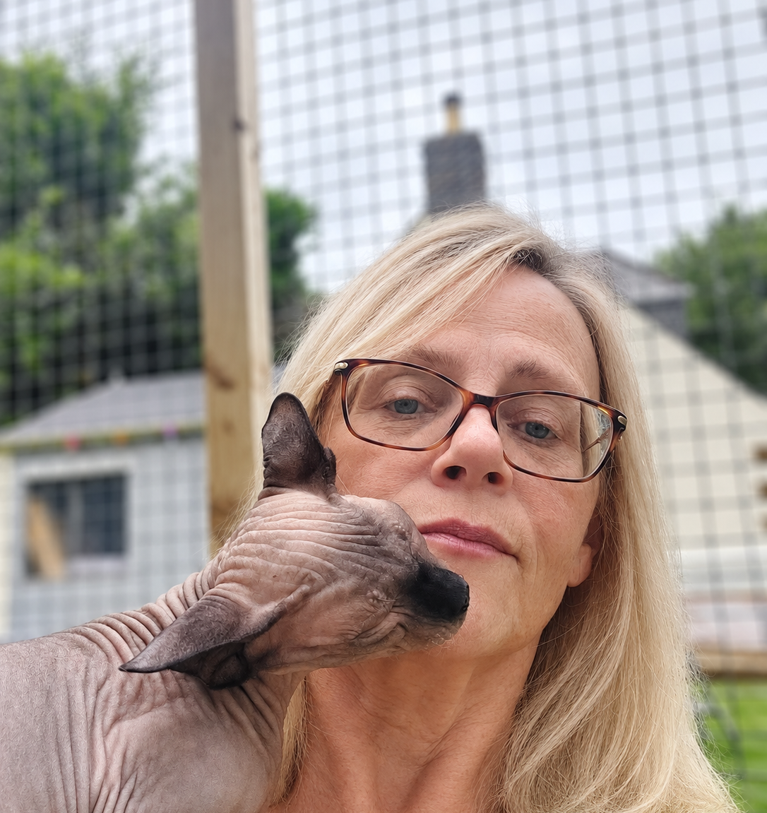 Meet the Breeder Behind RiviaSphynx RiviaSphynx breeder with one of her Canadian Sphynx cats in their outdoor cat enclosure.